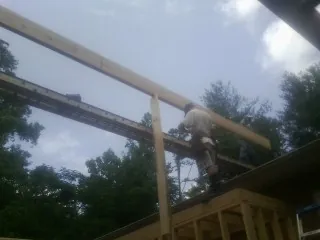 Carpenter setting a ridge beam over a new addition frame — Ice Dam Removal by Roofing Brothers in Spring Green
