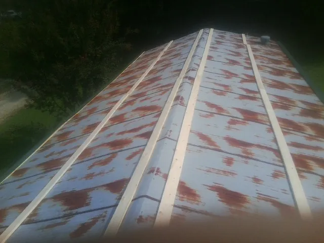 Rusted metal roof panels with new wood purlins before replacement — Storm Damage Roof Repair in Spring Green by Roofing Brothers