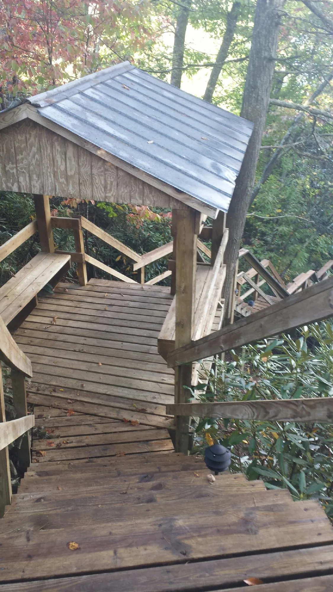 Metal roofed shelter over wooden steps on a wooded walkway — Skylight Repair & Installation work by our crew in Spring Green