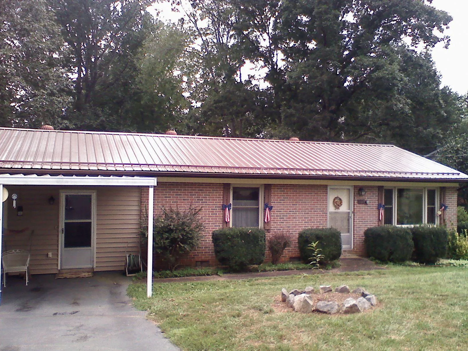 Bronze metal roof and carport on a brick ranch home — Roof Repair work by our crew in Spring Green